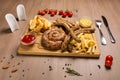 Set of grilled sausages a wooden board hunting sausages, pork sausages, homemade sausage, french fries, potato slices, tar-tar, Royalty Free Stock Photo