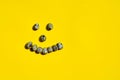 Set of group quail eggs form a smile face on a yellow background