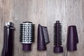 Set of hair dryer attachments on a wooden background. Curling iron, hair straightener. Hot styling, boar bristles, hair care. Royalty Free Stock Photo