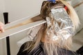 Set of hair dyeing. Bleaching powder applying on hair and wrapping into the foil. Air Touch technique. Step 1