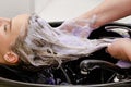 Set of hair dyeing. Hair stylist washing hair with no yellow shampoo after hair dyeing. Step 4 of 7 Royalty Free Stock Photo