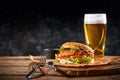Set of hamburger beer and french fries. A standard set of drinks and food in the pub, beer and snacks. Dark background Royalty Free Stock Photo