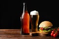 Set of hamburger beer and french fries. A standard set of drinks and food in the pub, beer and snacks. Dark background, fast food Royalty Free Stock Photo