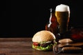 Set of hamburger beer and french fries. A standard set of drinks and food in the pub, beer and snacks. Dark background, fast food Royalty Free Stock Photo