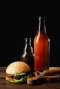 Set of hamburger beer and french fries. A standard set of drinks and food in the pub, beer and snacks. Dark background, fast food Royalty Free Stock Photo