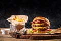 Set of hamburger and french fries. A standard set of drinks and food in the pub, beer and snacks. Dark background, fast Royalty Free Stock Photo