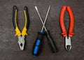 Set of hand tools pliers rubber pens and nippers in the center of a pair of screwdrivers on a dark background design of a home wiz