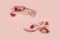 Set hands with artificial flowers sticking out of hole pink paper background. Hand in various poses, the pattern layout for your