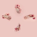 Set hands with artificial flowers sticking out of hole pink paper background. Hand in various poses, the pattern layout for your