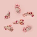 Set hands with artificial flowers sticking out of hole pink paper background. Hand in various poses, the pattern layout for your