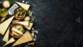 Set of hard cheeses with cheese knives on black stone background. Parmesan. Royalty Free Stock Photo