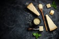 Set of hard cheeses with cheese knives on black stone background. Parmesan. Top view. Free space for your text Royalty Free Stock Photo