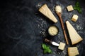 Set of hard cheeses with cheese knives on black stone background. Parmesan. Top view. Free space for your text Royalty Free Stock Photo
