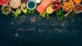 A set of healthy food. Fish, nuts, protein, berries, vegetables and fruits. On a black wooden background.