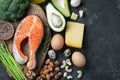 A set of healthy food for keto diet on a dark background. Fresh raw salmon steak with flax seeds, broccoli, avocado, chicken eggs Royalty Free Stock Photo