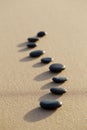 set of hot stone on white sand calm beach in backbone shape. selective focus, spa concept Royalty Free Stock Photo