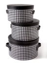 Set of houndstooth check and black leather bandboxes Royalty Free Stock Photo