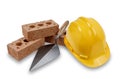 A set of house building bricks and trowel, with a yellow hard hat, isolated on a white background Royalty Free Stock Photo
