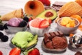 Set of ice cream scoops of different colors and flavours with berries, chocolate and fruits