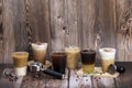 Set of iced coffee drinks arranging on dark brown wooden floor and background decorated by coffee beans group handle and tamper