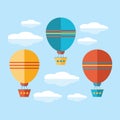 A set of icons in a flat vector. Yellow, blue and red air balloon, aerostat flying in the sky among the clouds. Travel by air