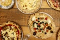 Set of Italian thin crust pizzas with black olives, cherry tomatoes, dried oregano, basil, eggplant slices, pomodoro tomato and Royalty Free Stock Photo