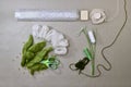 A set of items for needlework making snowdrops made of wool on a gray work surface, flat lay