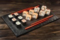 Set of japanese rolls on a stone dish with chopsticks