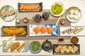 Set of Japanese sushi dishes, salmon in sashimi, California rolls, salmon makis, edamame tray and wakame with soy Royalty Free Stock Photo