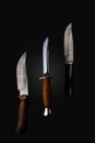 Set of knifes made of Damascus steel with a wooden handle on a isolated dark background