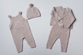 Set of knitted baby clothes. Newborn beige romper, hat, jumper, pants on neutral background. Winter, autumn unisex Royalty Free Stock Photo