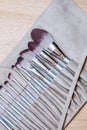 A set of large assorted makeup brushes are packed in a leather case on the make-up artist's desk. Vertical photo Royalty Free Stock Photo