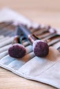 A set of large assorted makeup brushes are packed in a leather case on the make-up artist's desk. Vertical photo Royalty Free Stock Photo