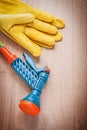 Set of leather gloves garden rubber hose water sprayer on wooden Royalty Free Stock Photo