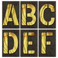 Set, letters A, B, C, D, E, F. Alphabet made of letters, made of wood, on a dark wooden plank. Isolated on white