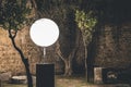Set of light with round shade lamp in the night. View of a stone wall and trees in the darkness Royalty Free Stock Photo