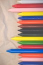 Set of lined up colored wax crayons on recycled paper background Royalty Free Stock Photo