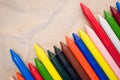 Set of lined up colored wax crayons on recycled paper background Royalty Free Stock Photo