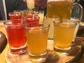 A set of lots of delicious yellow orange red glasses, shots with strong alcohol, vodka, brandy, brandy, beer on wooden stands Royalty Free Stock Photo