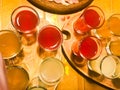 A set of lots of delicious yellow orange red glasses, shots with strong alcohol, vodka, filling, brandy on wooden stands Royalty Free Stock Photo