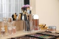 Set of luxury makeup products, accessories and perfumes on dressing table in room Royalty Free Stock Photo