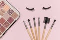 A set of makeup brushes, eye shadow and false eyelashes on a beige background Royalty Free Stock Photo