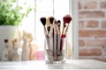 A set of makeup and cosmetic brushes in a colored jars on the table