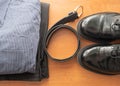 Set of man businessman wear clothes on a desk - pair of black shoes, pants, shirt and leather belt Royalty Free Stock Photo