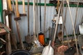 set of many different old rusty vintage gardening equipment near fence at shed storage in house backyard. Rustic agricultural home