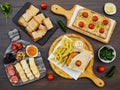 A set of many snacks for wine or beer: a burger with French fries, slicing cheese and smoked sausage, sandwiches with melted chees Royalty Free Stock Photo