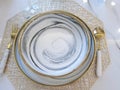 A set of marble-patterned dinner plates with accompanying spoons and forks is neatly arranged on the table. Royalty Free Stock Photo