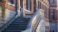 A set of marble stairs curves dramatically up the side of a tall brick building. The elegant steps are frequented by Royalty Free Stock Photo