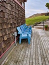 Set of blue chairs on a beachfront property patio on a clear day