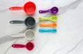 Set of measuring spoons and measuring cup made from colorful plastic lay on marble background Royalty Free Stock Photo